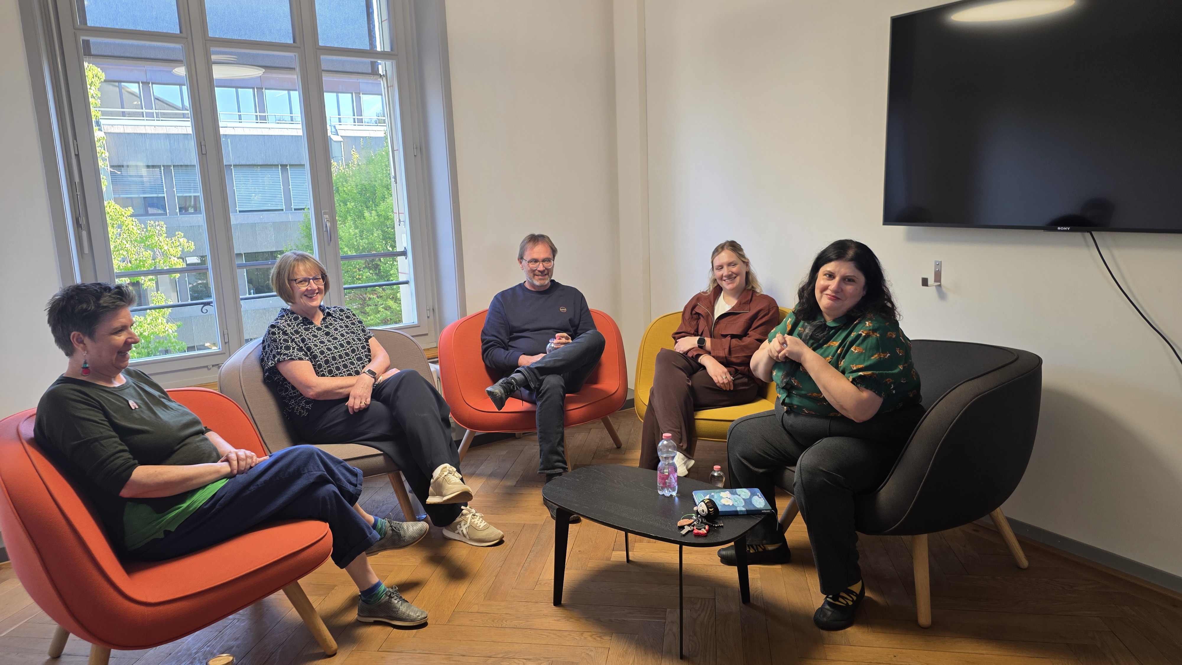 Four patient representatives sitting in a round being interviewed about taking part in research