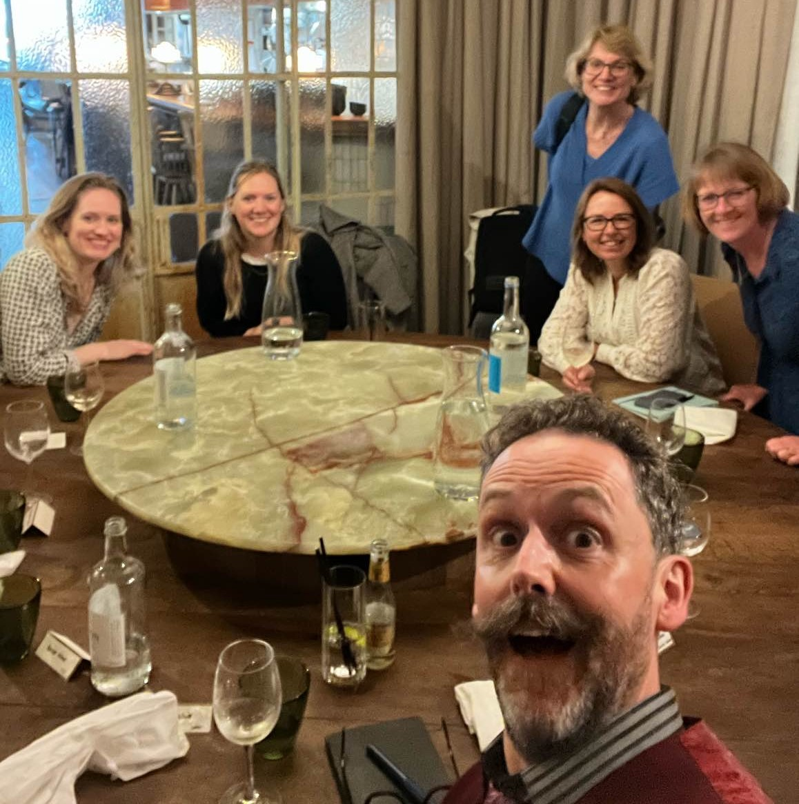 Patient Group Lunch - October 2023 Five women and one man (taking the selfie) around a round table all smiling.