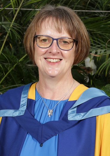 Fiona Copeland in royal blue dress with yellow and blue graduation gown